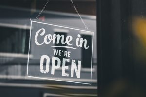 A door sign says 'come in we're open' in a shop door